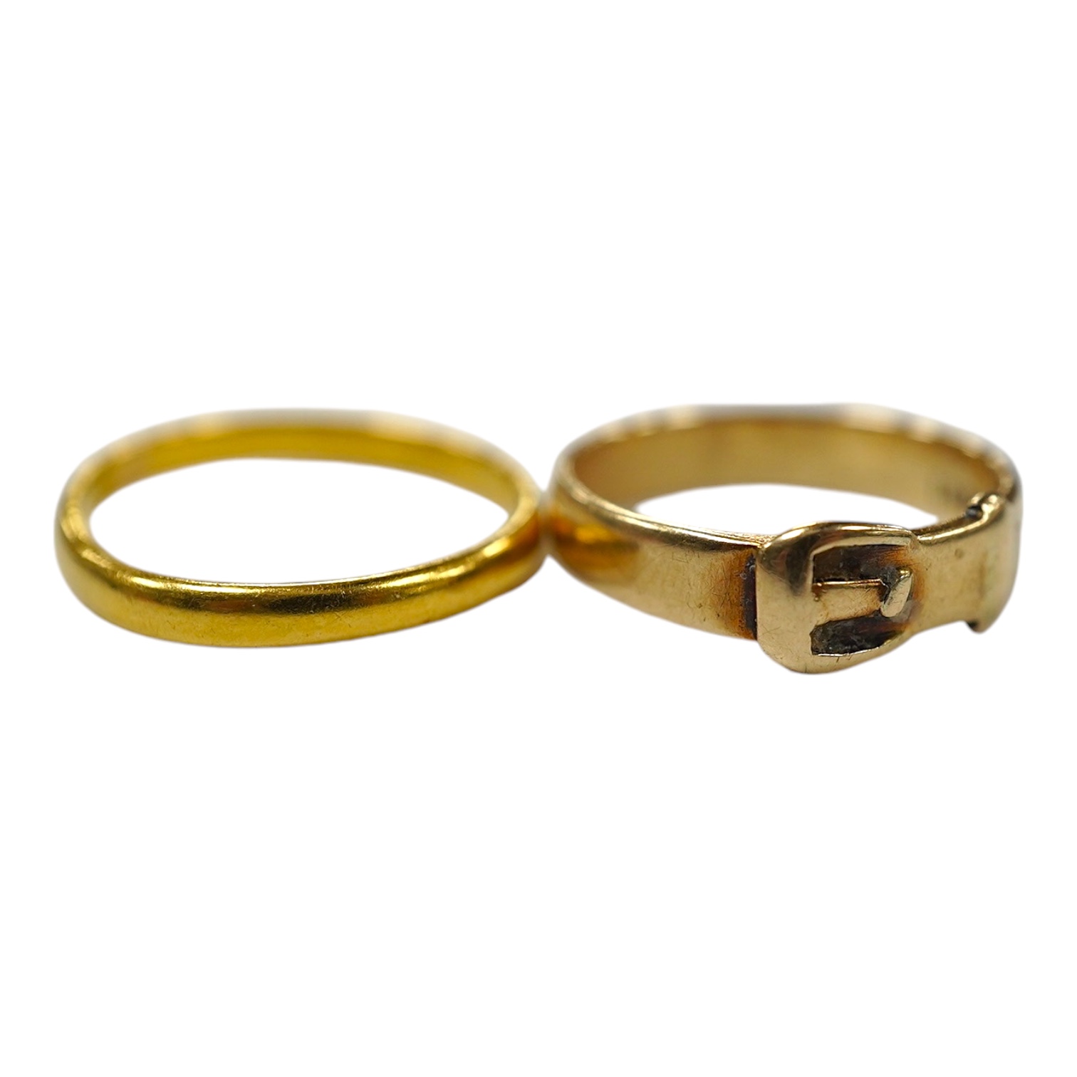 A modern 9ct gold buckle ring, 2.2 grams and a 22ct gold wedding band, 1.6 grams. Condition - poor